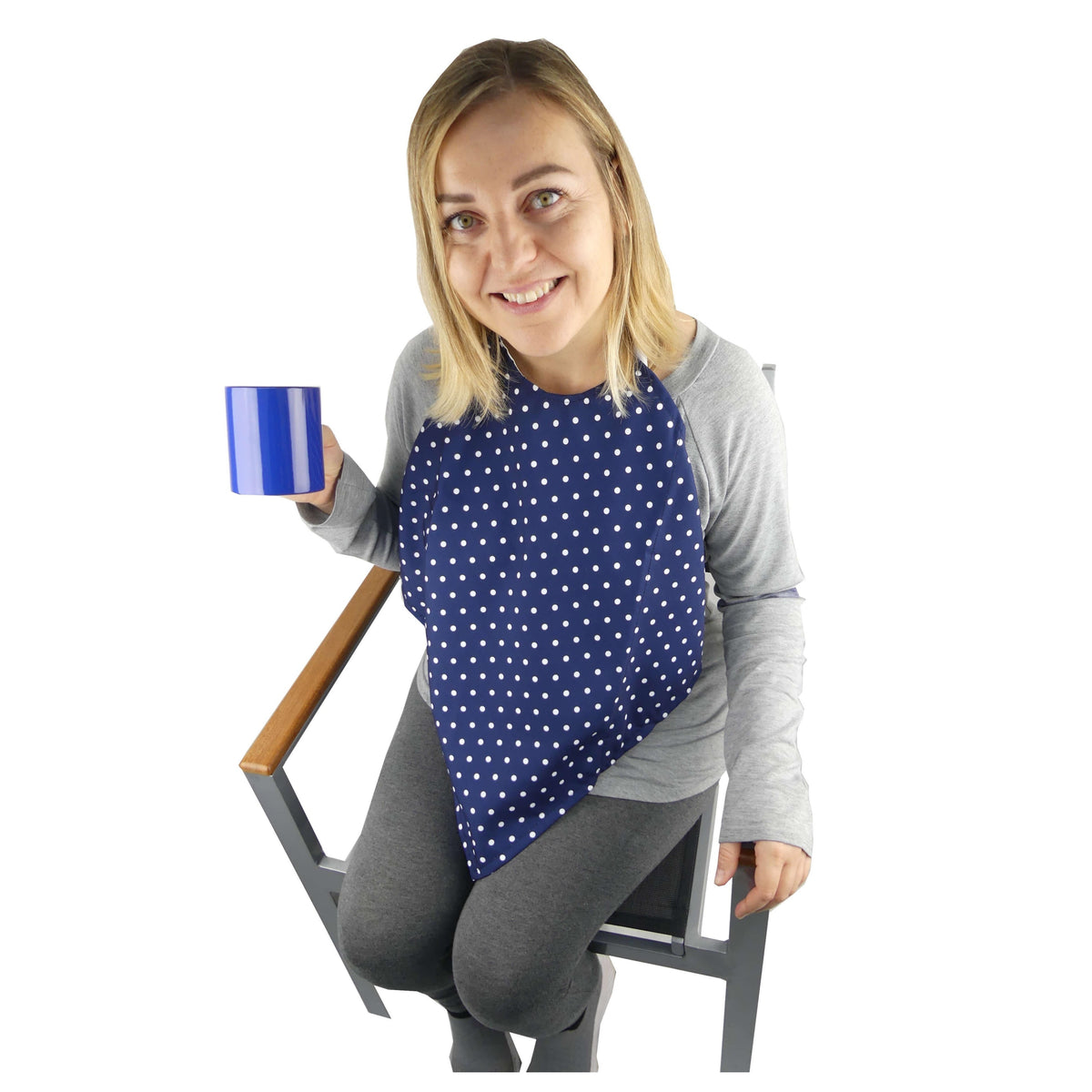 Woman seated wearing a navy spotted Catchkin clothing protector