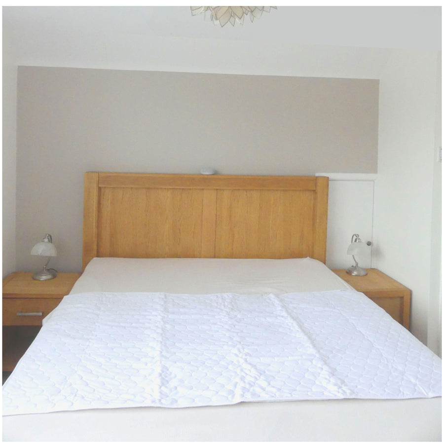 White washable incontinence bed pad on a bed